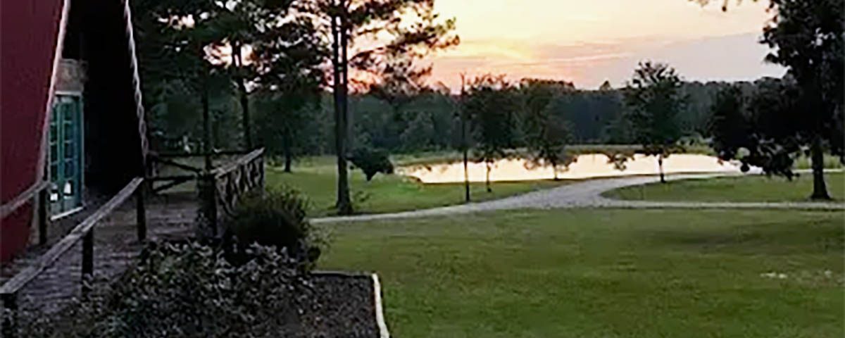 Fall sunset overlooking the pond and A-frame cabin at Deer Run RV Park in Troy, Alabama