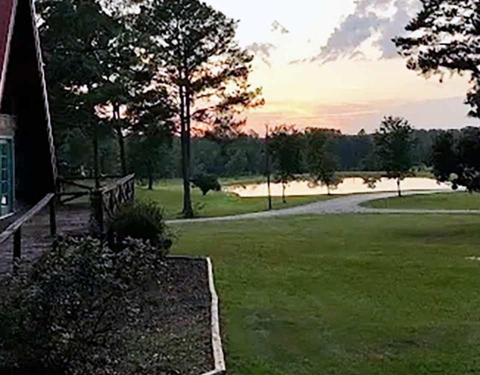 Fall sunset overlooking the pond and A-frame cabin at Deer Run RV Park in Troy, Alabama