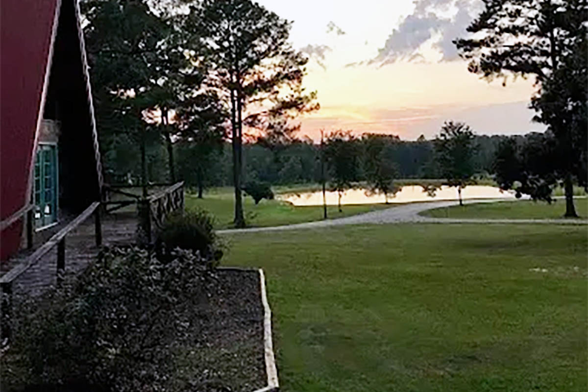 Fall sunset overlooking the pond and A-frame cabin at Deer Run RV Park in Troy, Alabama