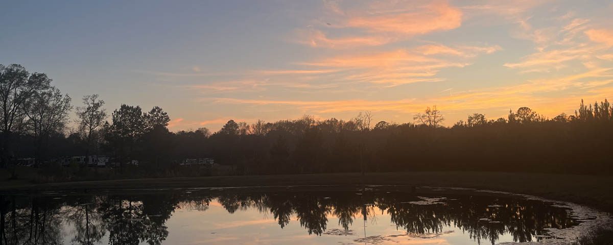 Peaceful September sunset reflecting across the pond at Deer Run RV Park in Troy, Alabama